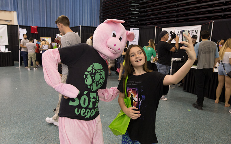 Kid taking selfie with SoFlo Vegans Mascot